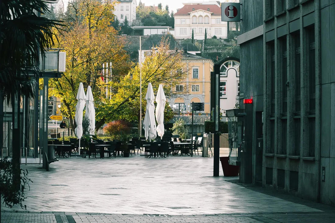 Belebter Stadtplatz mit Cafés und Menschen in einem urbanen Kiez